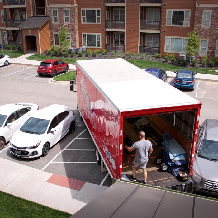 mover standing in a moving truck in an apartment complex