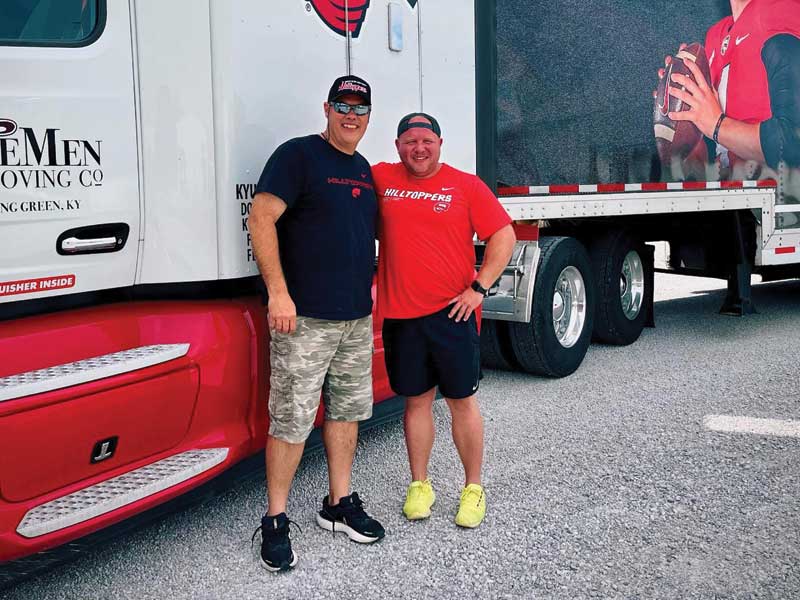 two WKU fans standing in front of semi truck